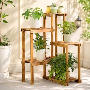 May include: A multi-tiered wooden plant stand with a natural brown finish, featuring several slatted shelves at varying heights. The stand holds six potted plants, including small succulents in colourful pots and larger green leafy plants in white pots.