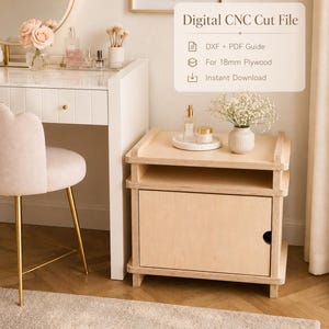 May include: A light wood nightstand with a cabinet door and open shelf. The nightstand is next to a white vanity with a gold-framed mirror and a pink upholstered chair. The text "Digital CNC Cut File" is displayed.