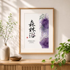 May include: Framed art print featuring Japanese calligraphy and watercolor floral elements in shades of purple and green. The text reads "SHINRIN-YOKU Forest Bathing". The artwork is displayed in a wooden frame.