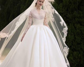 Vestido de novia de satén de manga larga con encaje francés y cola catedral.