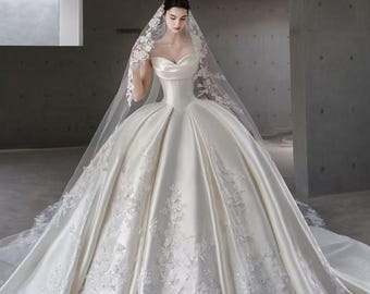 Vestido de novia de satén hecho a mano con escote corazón, cola de encaje floral, velo catedral con borde de encaje y atuendo nupcial personalizado.