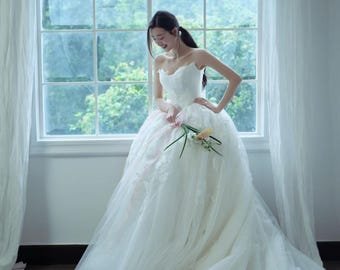 Vestido de novia de gala sin tirantes de encaje y satén, romántico vestido de cuento de hadas con lazo de cinta rosa y elegante falda voluminosa de tul.
