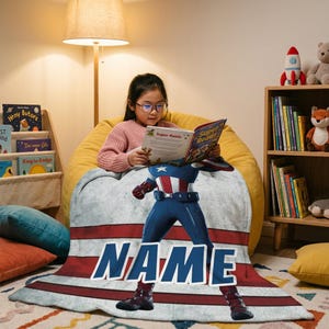 May include: A personalized Captain America blanket with a red, white, and blue design. The blanket features the word "NAME" in bold blue letters. A young person is reading a book while sitting on a yellow beanbag chair.