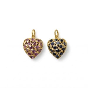 May include: Two heart-shaped pendants with gold-coloured metal settings. One pendant is filled with purple gemstones, and the other with dark blue gemstones. Both have a small loop at the top for a chain.