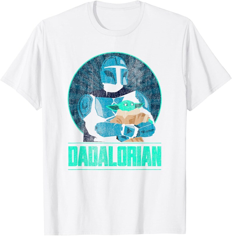 以下が含まれることがあります： 白いTシャツ。青と白のマンダロリアン風のキャラクターが緑色のエイリアンを抱いているグラフィック。テキスト「DADALORIAN」はターコイズ色で画像の下に印刷されています。