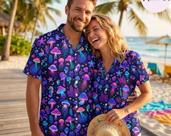 Peut inclure: Une chemise à manches courtes boutonnée avec un motif vibrant aux couleurs néon représentant des champignons, des méduses et des étoiles de mer sur un fond bleu marine. Le design présente des teintes vives de rose, bleu et violet.
