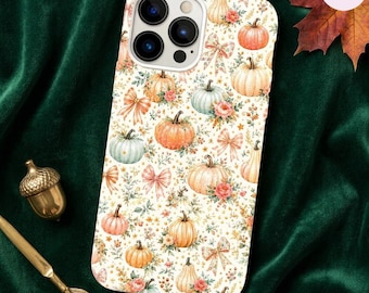 Peut inclure: Une coque de smartphone avec un motif répétitif de citrouilles orange et blanches, de nœuds rose pâle et de petits accents floraux sur un fond crème. Le design présente diverses formes et tailles de citrouilles avec des éléments botaniques.