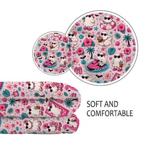 Puede incluir: Una tela rosa con un patr&oacute;n repetitivo de fantasmas blancos con gafas de sol y accesorios tropicales como flores de hibisco, palmeras y conchas marinas. Algunos fantasmas est&aacute;n en motos de agua. El texto dice SOFT AND COMFORTABLE.
