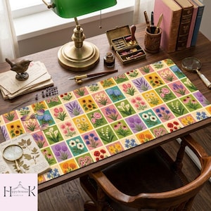 May include: A rectangular desk mat featuring a grid of colorful botanical illustrations of various flowers including sunflowers, tulips, lavender, and daisies, set against a wooden desk with a green lamp, books, and a magnifying glass.