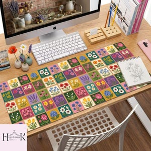 May include: A rectangular desk mat featuring a grid pattern of colorful square illustrations of various flowers including tulips, poppies, daisies, and hydrangeas in shades of yellow, pink, blue, red, and green on a light-colored background.