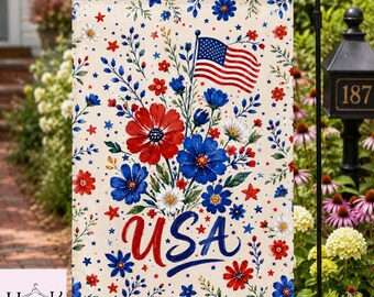 Peut inclure: Un drapeau de jardin rectangulaire sur fond crème orné d'un motif de fleurs rouges et bleues, de feuilles vertes et de petites étoiles. Un petit drapeau américain est représenté en haut au centre, avec le mot USA écrit en grandes lettres cursives.