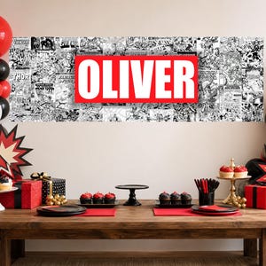May include: A rectangular banner featuring a black and white comic book collage background with a large red horizontal rectangle in the center containing the white text OLIVER in bold capital letters, displayed above a wooden party table.