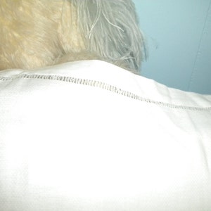 May include: White cotton pillowcase with a delicate stitched edge.