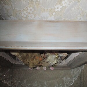 May include: A white wooden box with a distressed finish. The box is open and filled with lace, ribbon, and other decorative items.
