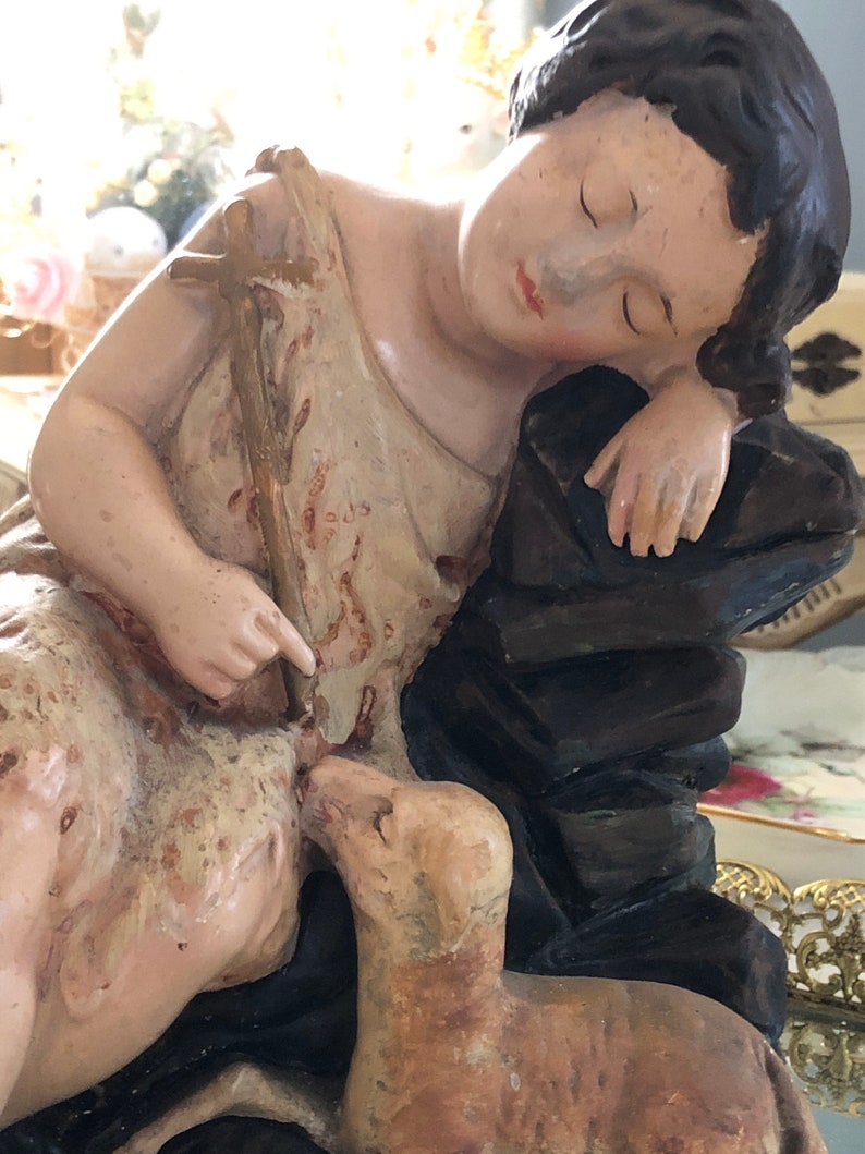May include: A vintage figurine of a sleeping girl with a lamb. The girl is wearing a white dress and has long brown hair. The lamb is brown and white and is lying next to the girl.