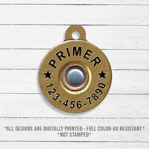 May include: Gold-colored metal dog tag with a black primer design and the text "PRIMER" and "123-456-7890".