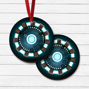 May include: Two round, blue and brown Christmas ornaments with a metallic, circular design. The ornaments feature a blue and white light in the center.