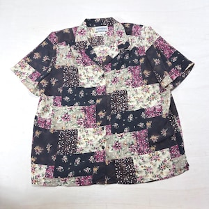 May include: A short-sleeved button-down shirt featuring a patchwork design of various floral patterns in shades of dark navy, cream, and deep magenta. The collar is pointed, and the brand label DONNKENNY is visible at the inside neckline.