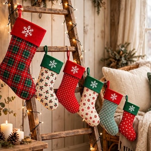 Puede incluir: Seis calcetines navideños de diferentes tamaños colgados de una escalera de madera. Los calcetines presentan telas de cuadros rojos y verdes, crema con patrones florales, rojos con lunares blancos y cuadros vichy verdes, con un copo de nieve.