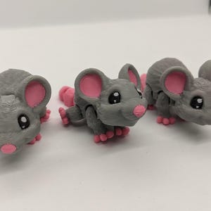 May include: Three small gray mouse figurines with pink ears and noses. The mice have black eyes and are posed in different positions.