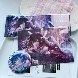 Peut inclure: Une impression rectangulaire et un badge circulaire représentant un personnage de style anime aux longs cheveux sombres, avec des accessoires de cheveux en plumes blanches et un bandeau. L'illustration présente des tons violets et bleu foncé.