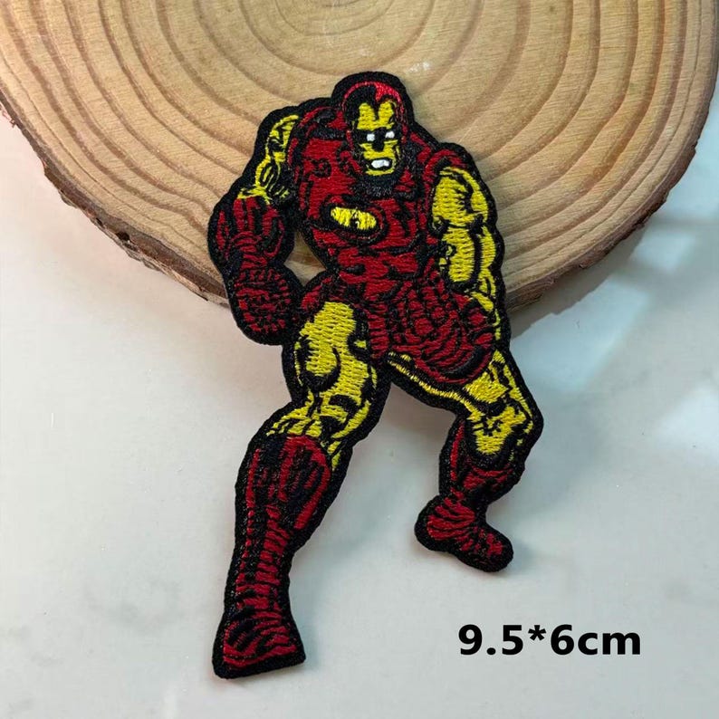 May include: Embroidered patch of Iron Man in a dynamic pose, with red and yellow detailing. The patch measures 9.5 x 6 cm. The design features the superhero's iconic armour, with detailed stitching and vibrant colours, suitable for clothing or accessories.