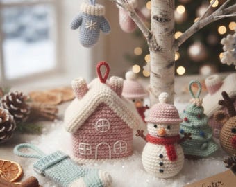 Könnte beinhalten: Eine Sammlung gehäkelter Weihnachtsschmuckstücke, darunter ein rosa Haus mit weißem Dach, ein Schneemann mit rotem Schal, ein hellblauer Strumpf, ein hellblauer Weihnachtsbaum und ein hellblauer Fäustling, mit einem Schild Winter Whimsy Collection.