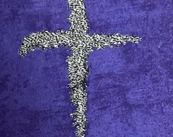 Könnte beinhalten: Ein leuchtend violetter Stoffhintergrund mit einem zentrierten, strukturierten Kreuzdesign. Das Kreuz ist aus metallischem Silberfaden mit ausgefransten, organischen Kanten gefertigt und bildet einen starken Kontrast zur tiefvioletten Textiloberfläche.