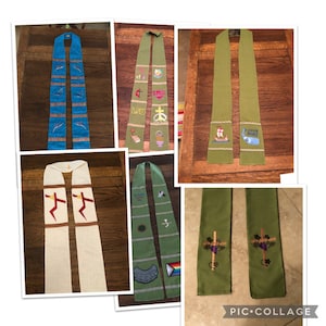 K&ouml;nnte beinhalten: Eine Collage verschiedener Stolen, jede mit einzigartigen Designs. Eine ist blau mit Vogelmotiven, eine andere gr&uuml;n mit religi&ouml;sen Symbolen und Text, und weitere in Creme und Gr&uuml;n mit Kreuzen und anderen Emblemen. Die Stolen werden auf einer Holzoberfl&auml;che pr&auml;sentiert.
