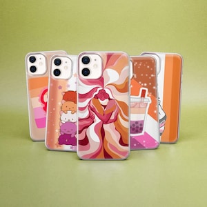 May include: Five clear smartphone cases featuring various designs including a stack of five colorful cats, a central illustration of two figures embracing with flowing hair, a boba tea drink, and abstract orange, pink, and white color patterns.