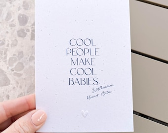 Könnte beinhalten: Eine rechteckige weiße Karte mit gesprenkelter Textur und dem dunkelblauen Text COOL PEOPLE MAKE COOL BABIES. Darunter befindet sich der in Blau gedruckte handschriftliche Text Willkommen kleiner Anton sowie ein kleines weißes Herz-Relief.