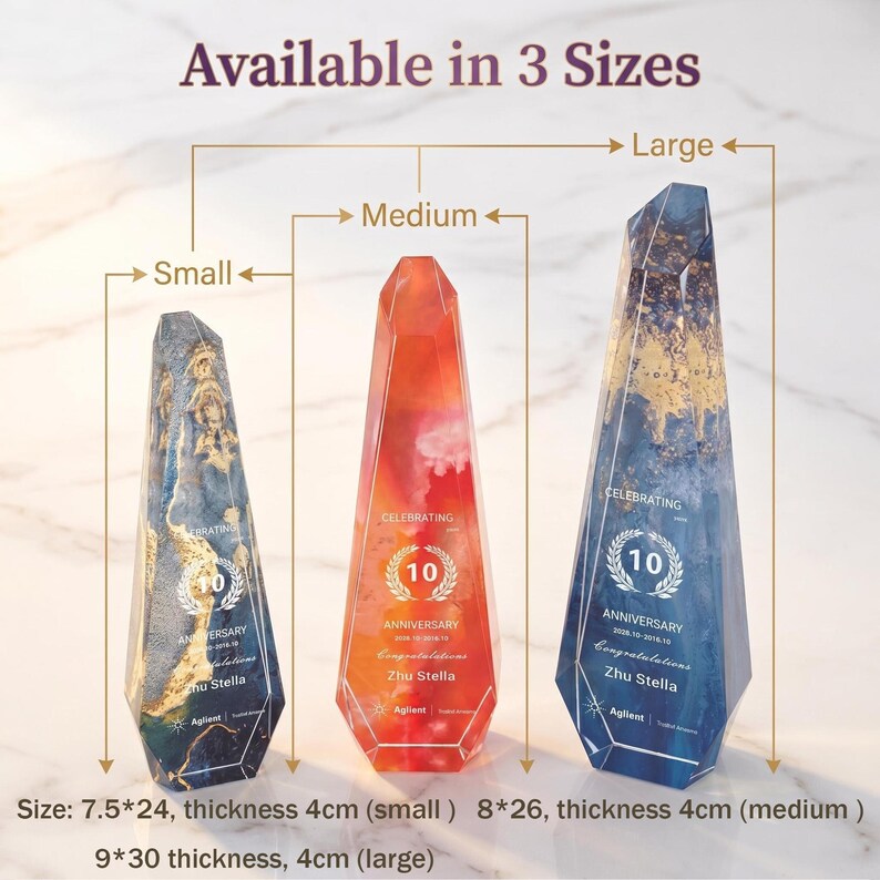 May include: Three decorative prism-shaped awards in blue, orange, and blue with gold accents. Each award has a 10-year anniversary design and the text "Celebrating Anniversary". The small award is 7.5 inches by 9.4 inches.