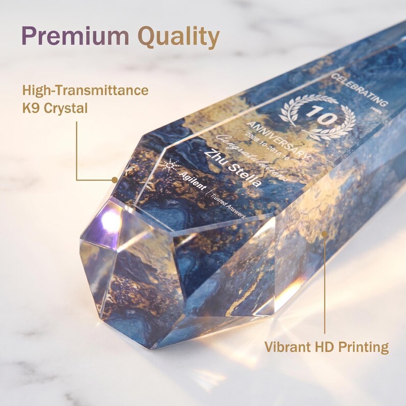 May include: A clear, faceted crystal award with blue and gold marbling. The text "10 Anniversary" and "Zhu Stella" are visible. The award is labeled "Premium Quality" and "High-Transmittance K9 Crystal."