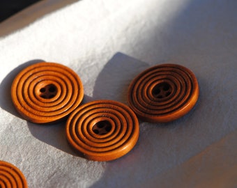 May include: Four brown wooden buttons with concentric circles and a four-hole centre.