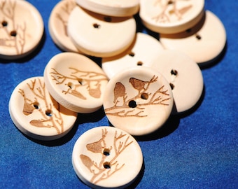 May include: A collection of wooden buttons with a nature-inspired design. Each button features a pair of birds perched on a branch, with intricate details carved into the wood. The buttons are a light brown color and have a smooth, polished finish.