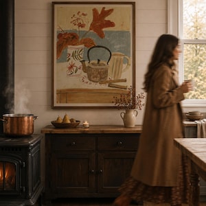 May include: A framed wall art print featuring a still life painting of a patterned vase, a teapot, and a mug on a table. The artwork uses warm tones of orange, brown, and cream, set against a light blue background, displayed in a simple wooden frame.