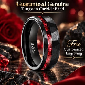 Könnte beinhalten: Ein schwarzer Ring aus Wolframkarbid mit facettierter Außenfläche und einer mittigen Einlage aus zerkleinertem rotem Material. Die Innenseite des Rings ist glatt und zeigt die Gravur B&S. Der Text Guaranteed Genuine Tungsten Carbide Band und Free Customized Engraving ist im Bild zu sehen.