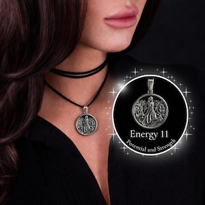 May include: A silver pendant necklace featuring a circular charm with a detailed relief of a woman in a flowing gown. The pendant hangs from a black cord choker. The image also includes the text "Energy 11 Potential and Strength".