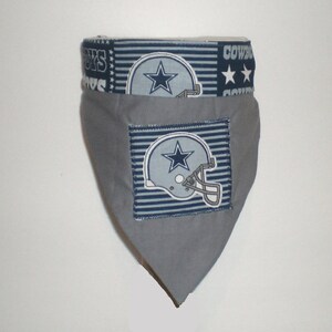 May include: Grey dog bandana with a blue and white Dallas Cowboys logo and the words "Cowboys" and "Boys" on the top edge.