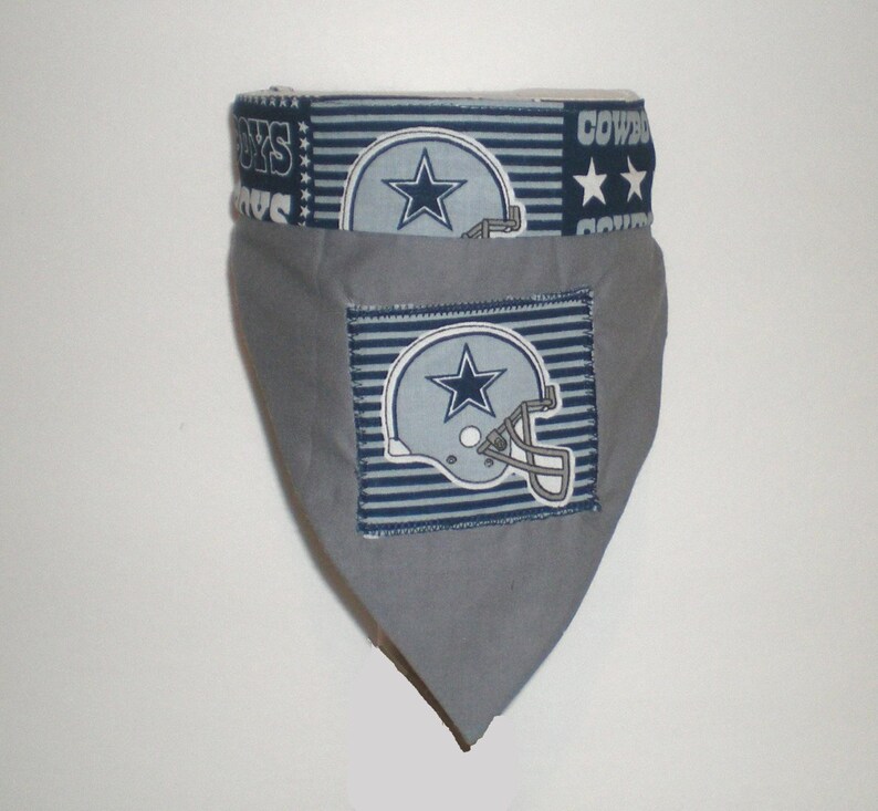 May include: Grey dog bandana with a blue and white Dallas Cowboys logo and the words "Cowboys" and "Boys" on the top edge.