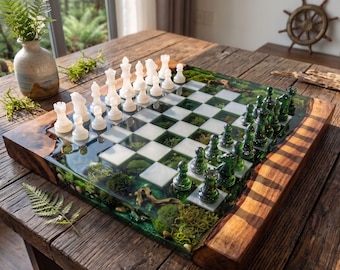 Op de afbeelding: Een schaakspel met een bord van hout met natuurlijke randen en heldere hars, waarin mos en kleine steentjes zijn verwerkt. De set bevat ondoorzichtige witte schaakstukken aan de ene kant en doorschijnende groene schaakstukken aan de andere kant.