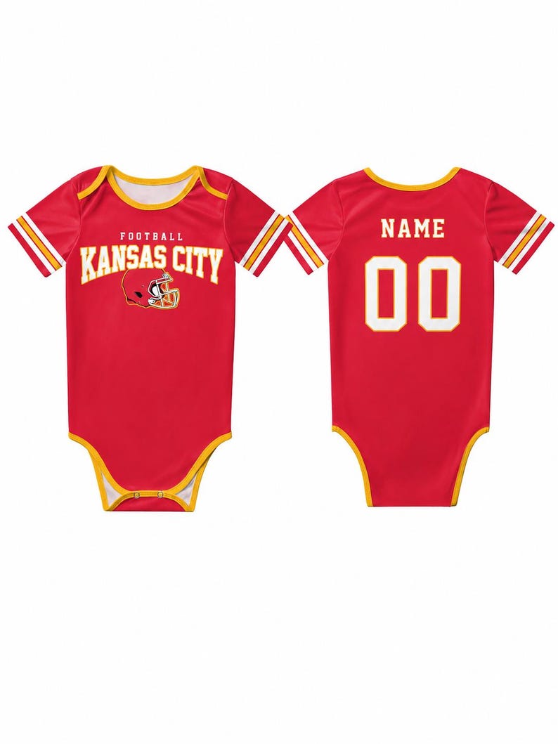 May include: Red baby bodysuit with yellow trim and white and gold stripes on the sleeves. The front features "FOOTBALL KANSAS CITY" in white text with a helmet graphic. The back has "NAME" above the number "00" in white.