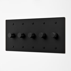 May include: A rectangular matte black wall plate featuring five cylindrical knobs with a textured knurled grip. The plate is secured to the wall with ten matching black flathead screws arranged in two horizontal rows above and below the knobs.