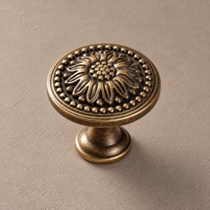Bouton de meuble en laiton antique, motif chrysanthème, en laiton massif avec bordure perlée.