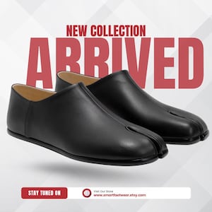 Op de afbeelding: Een paar zwarte leren schoenen met split-teen. De schoenen hebben een laag profiel en een uniek ontwerp met een splitsing tussen de grote teen en de andere tenen. De tekst "NEW COLLECTION ARRIVED" staat in het rood bovenaan de afbeelding.
