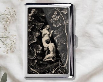 Könnte beinhalten: Ein rechteckiges Zigarettenetui aus silberfarbenem Metall mit einer schwarz-weißen Gravur von zwei Figuren in einer Waldlandschaft. Das Bild zeigt eine stehende und eine kniende Figur, umgeben von detaillierten Bäumen und Blattwerk.