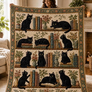 Puede incluir: Una colcha rectangular con un patrón de estantes repetitivo que muestra gatos negros, plantas en macetas y pilas de libros. El borde tiene un motivo floral. Los libros tienen nombres visibles que incluyen Luna, Shadow, Sunny, Milo, Bela, Nela, Simba, Lily y Charlie.