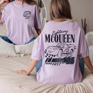 Pu&ograve; includere: T-shirt lilla chiaro con una grafica di Saetta McQueen del film Cars. La parte posteriore della maglietta mostra la scritta "Lightning McQueen" sopra una grafica di auto e il numero 95. La parte anteriore ha una grafica di auto pi&ugrave; piccola e la parola "NAME".