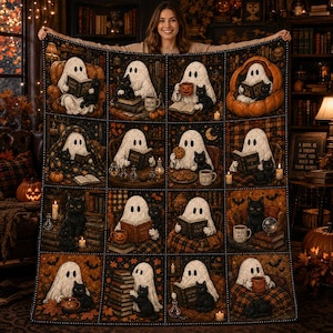 May include: A rectangular throw blanket featuring a grid of sixteen illustrations depicting ghosts and black cats in cozy settings. The scenes include ghosts reading books, drinking from mugs, and sitting with cats amidst autumn leaves and candles.
