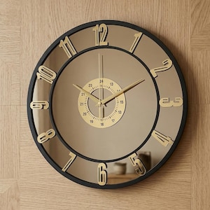 Peut inclure: Une horloge murale ronde avec un cadre noir et un cadran miroir. Des chiffres dorés indiquent les heures, et des aiguilles dorées indiquent l'heure. Le design de l'horloge est moderne et élégant.